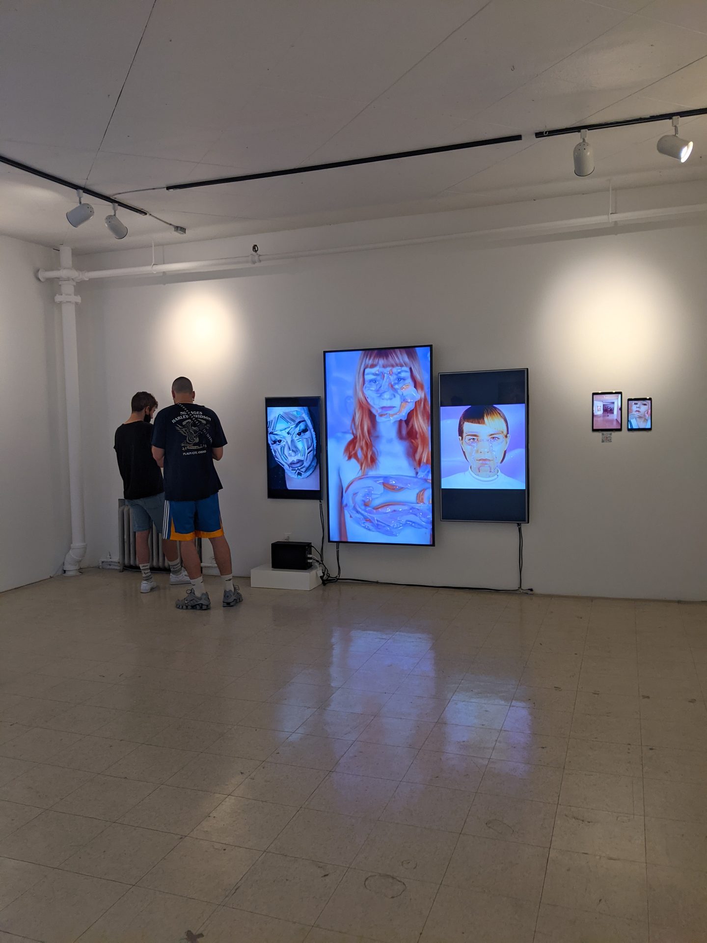 Alpha Manifestations — visitor near large blue AR cosmetics screen at Art Mûr