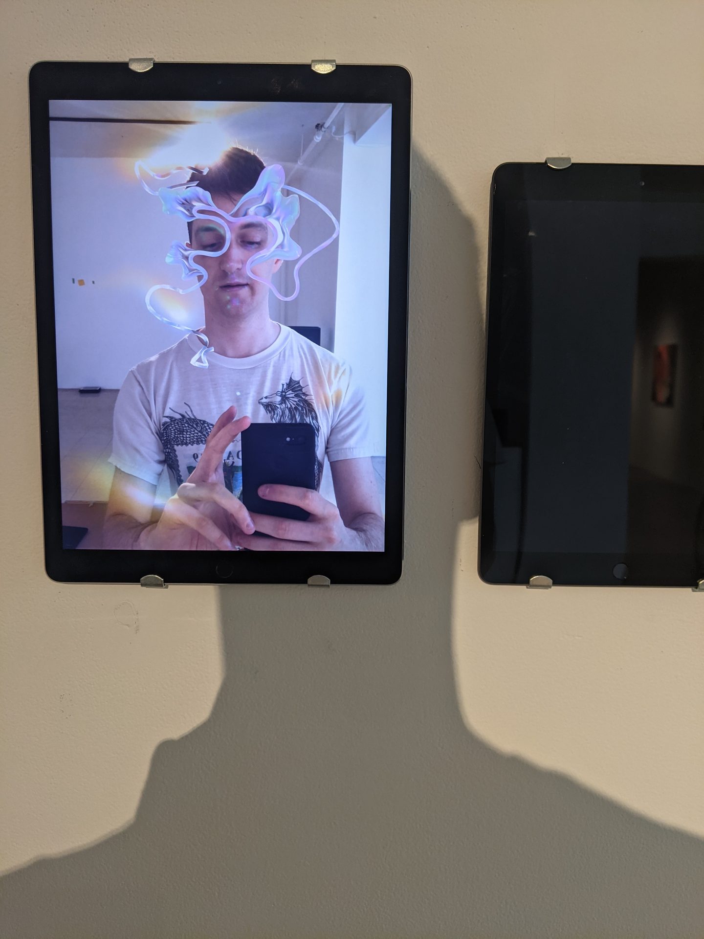 Alpha Manifestations — visitor experiencing AR cosmetics filter on iPad, digital tendrils on face