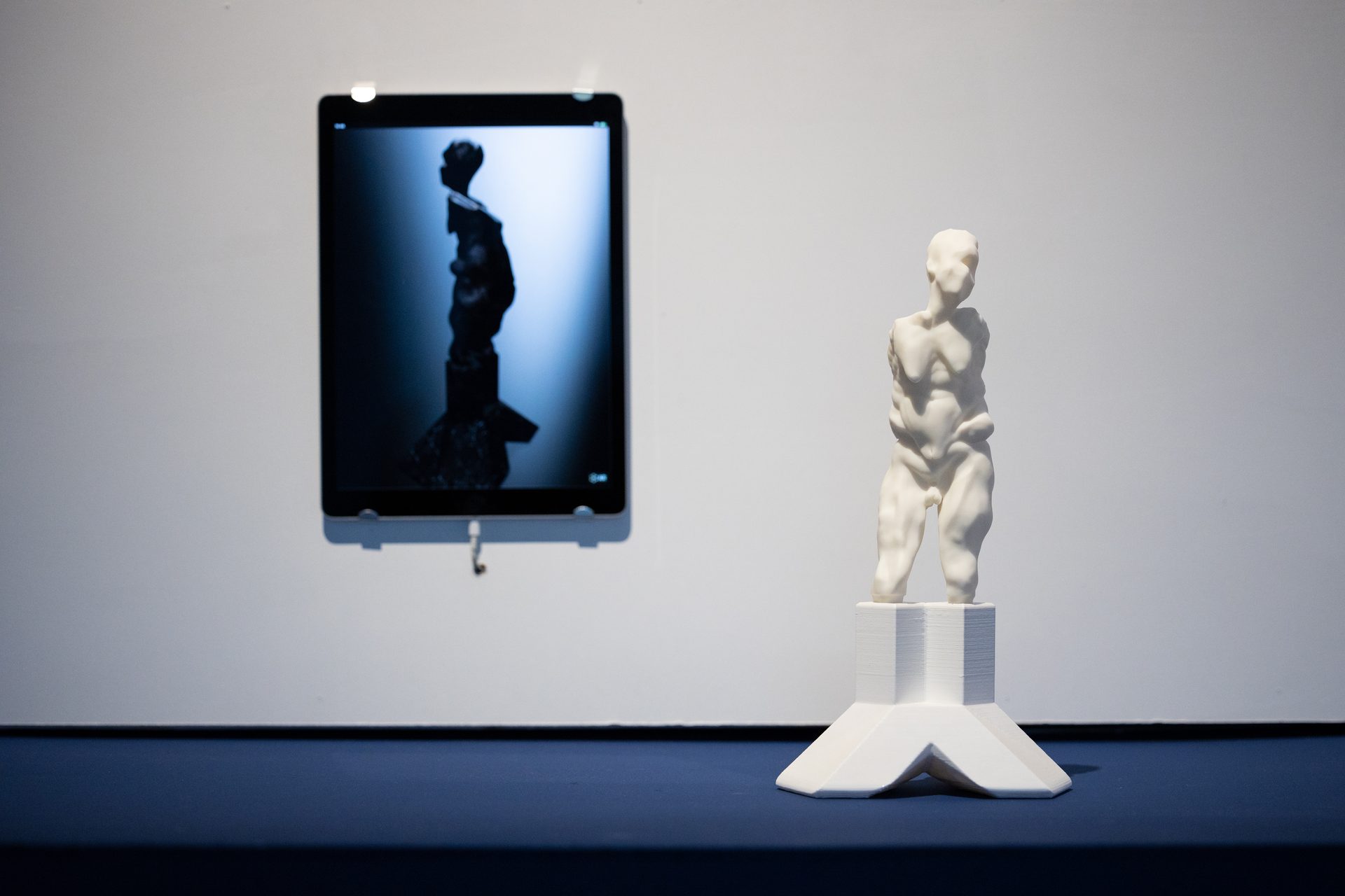 Auriea Harvey — silhouette on screen with 3D-printed figure, atmospheric gallery lighting