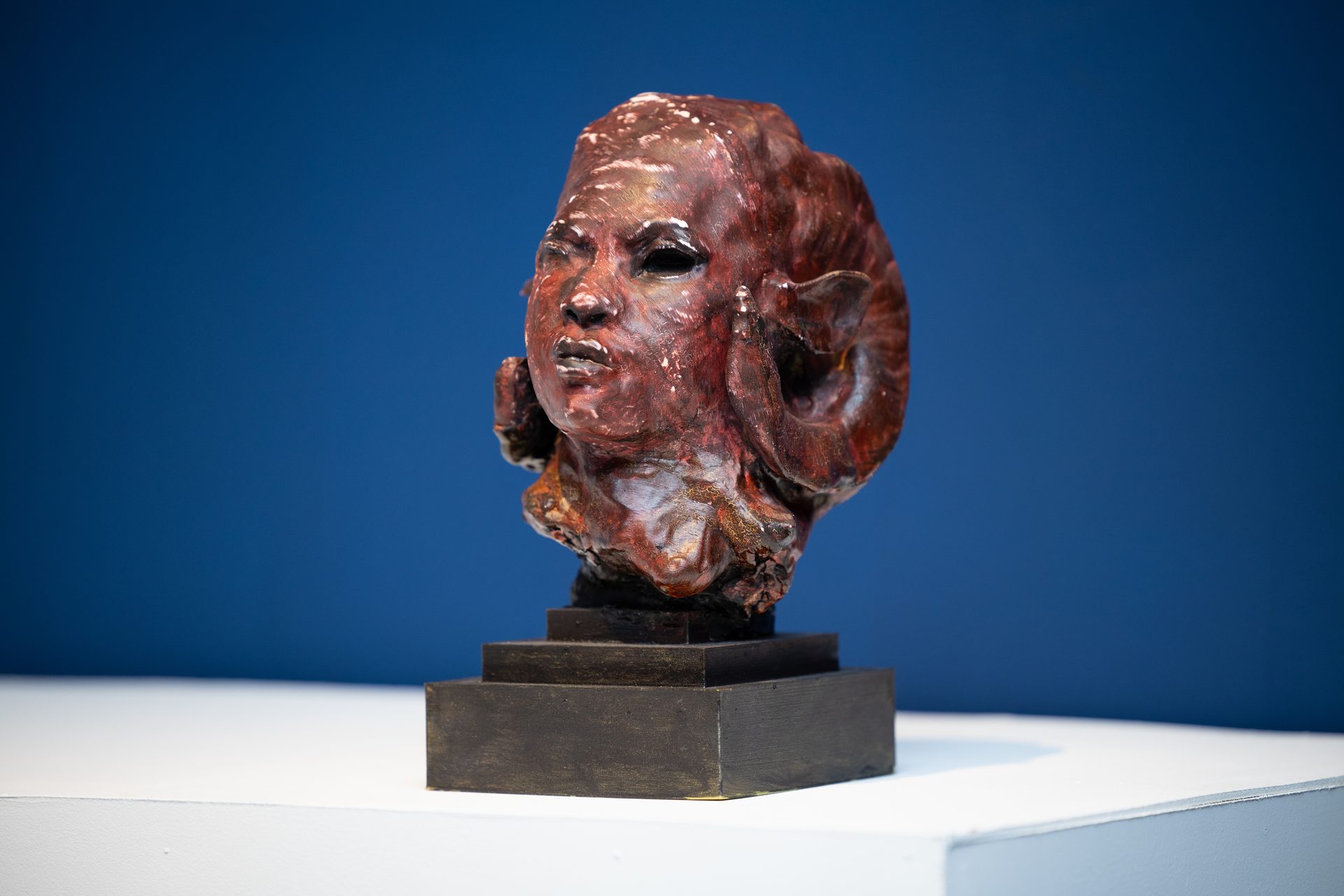 Auriea Harvey — Ancestor Red sculpture on pedestal, deep blue gallery wall