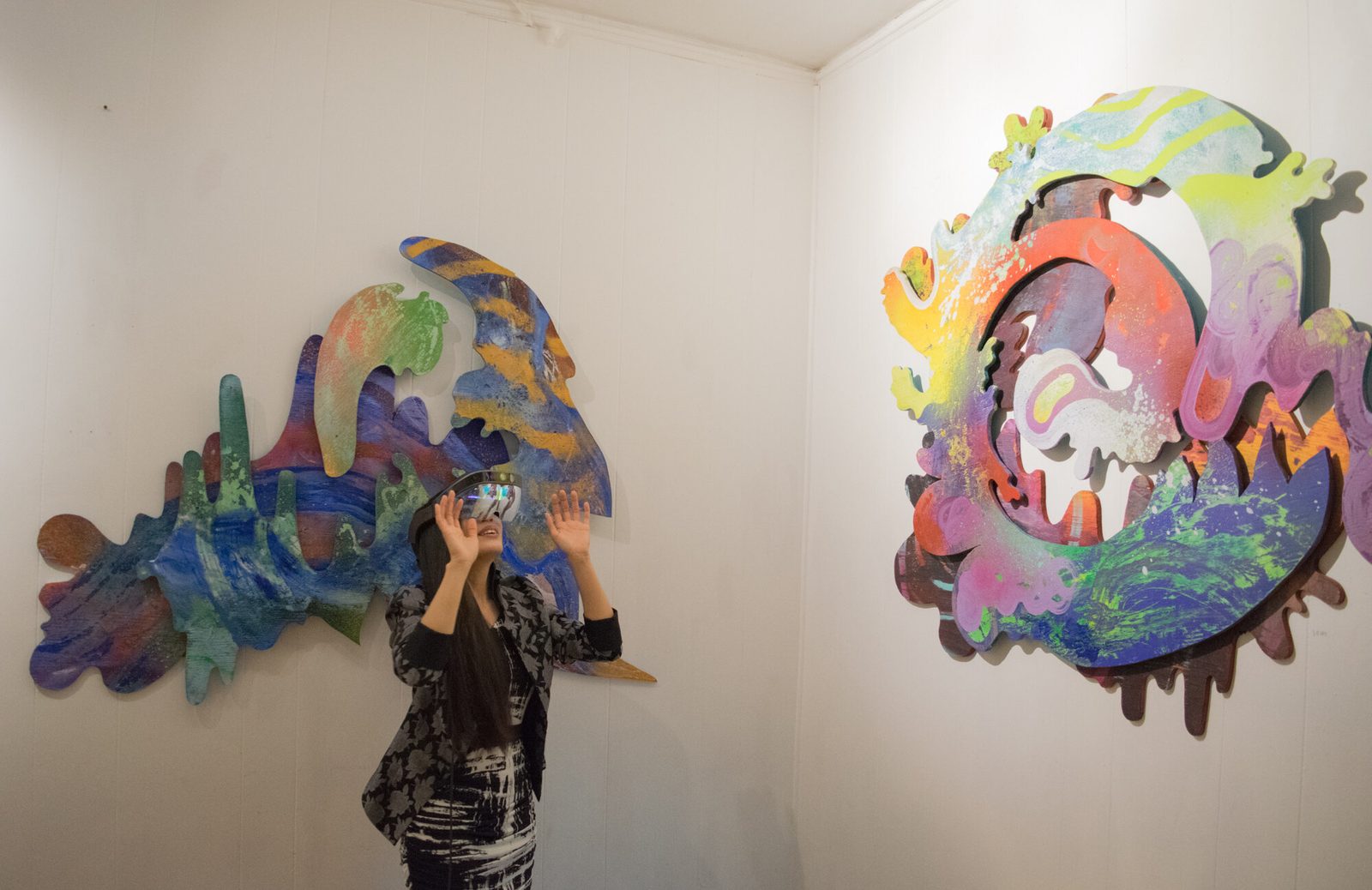 Illusive Sympathy — crowded gallery opening with visitors wearing AR headsets amid colorful graffiti murals