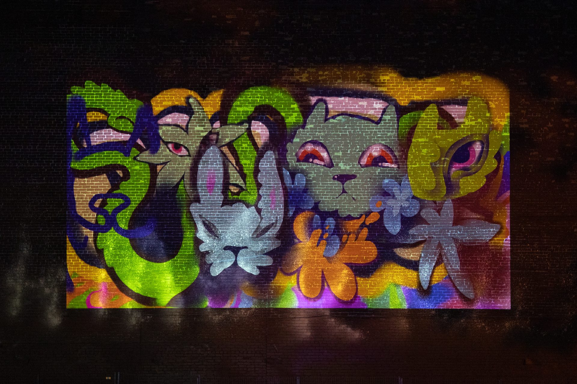 Cryote's projected VR graffiti — detailed creature forms in vivid color on brick wall