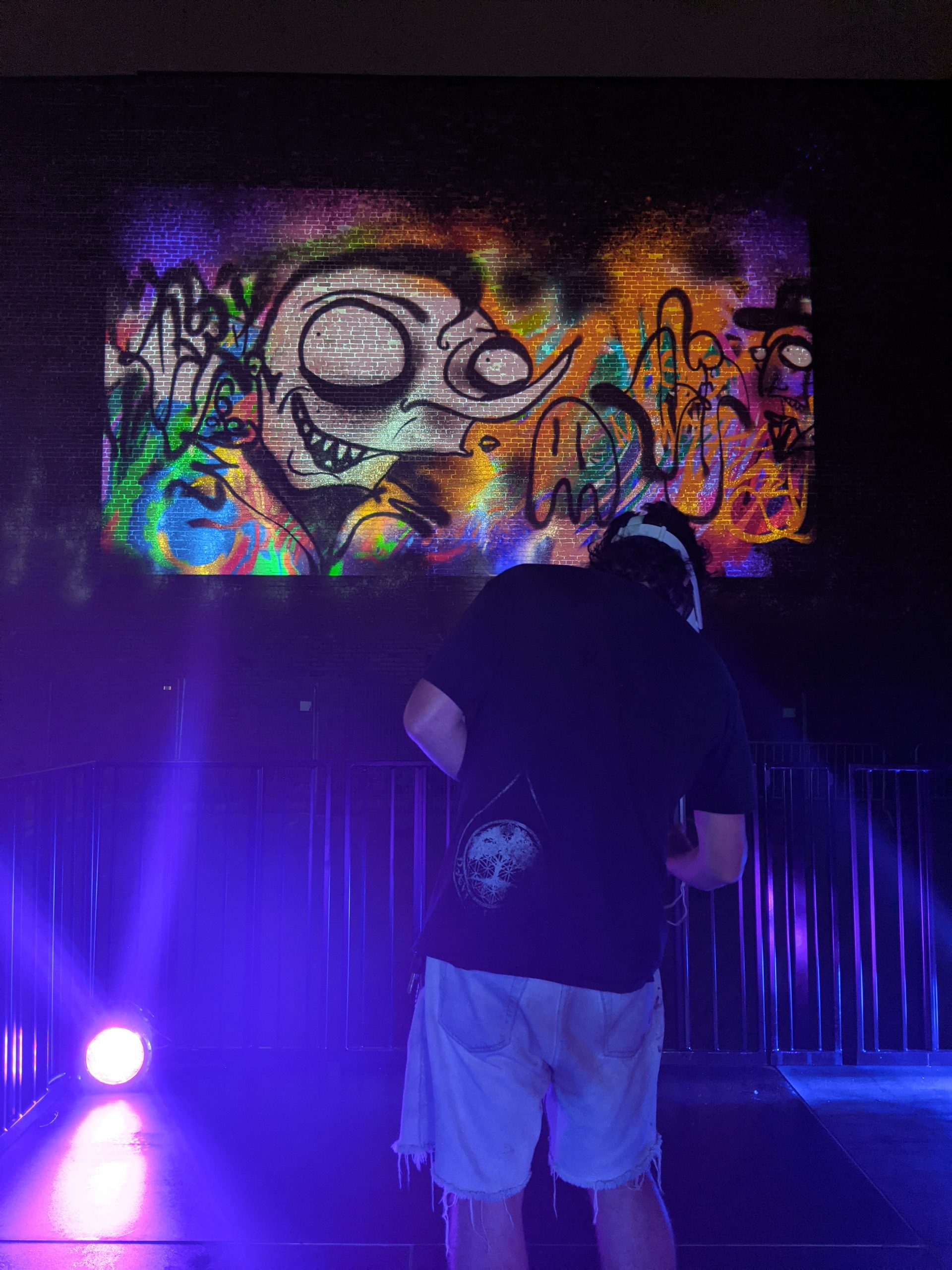 azdead posing with his projected VR graffiti at MURAL Festival