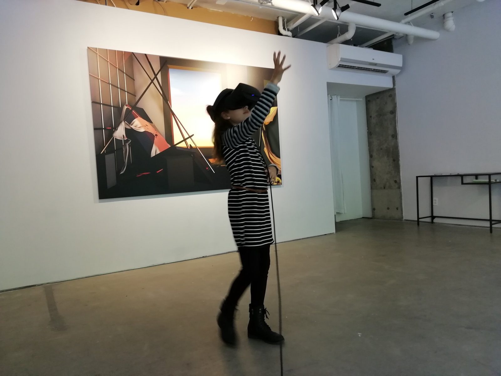 Salvo exhibition — visitor reaching upward in VR headset, Salvo print on wall behind