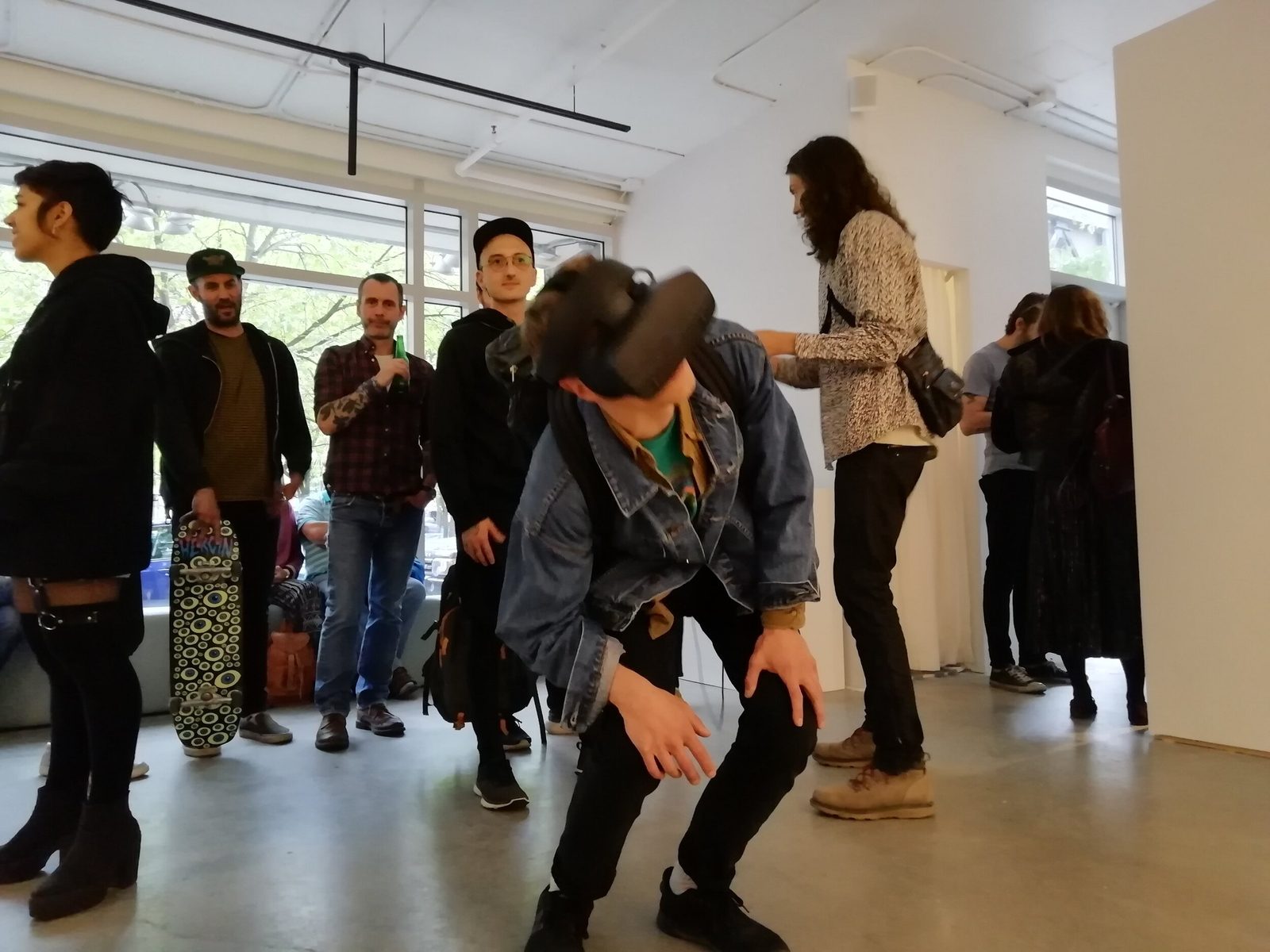 Salvo exhibition — visitor crouching in VR headset as crowd watches at gallery opening