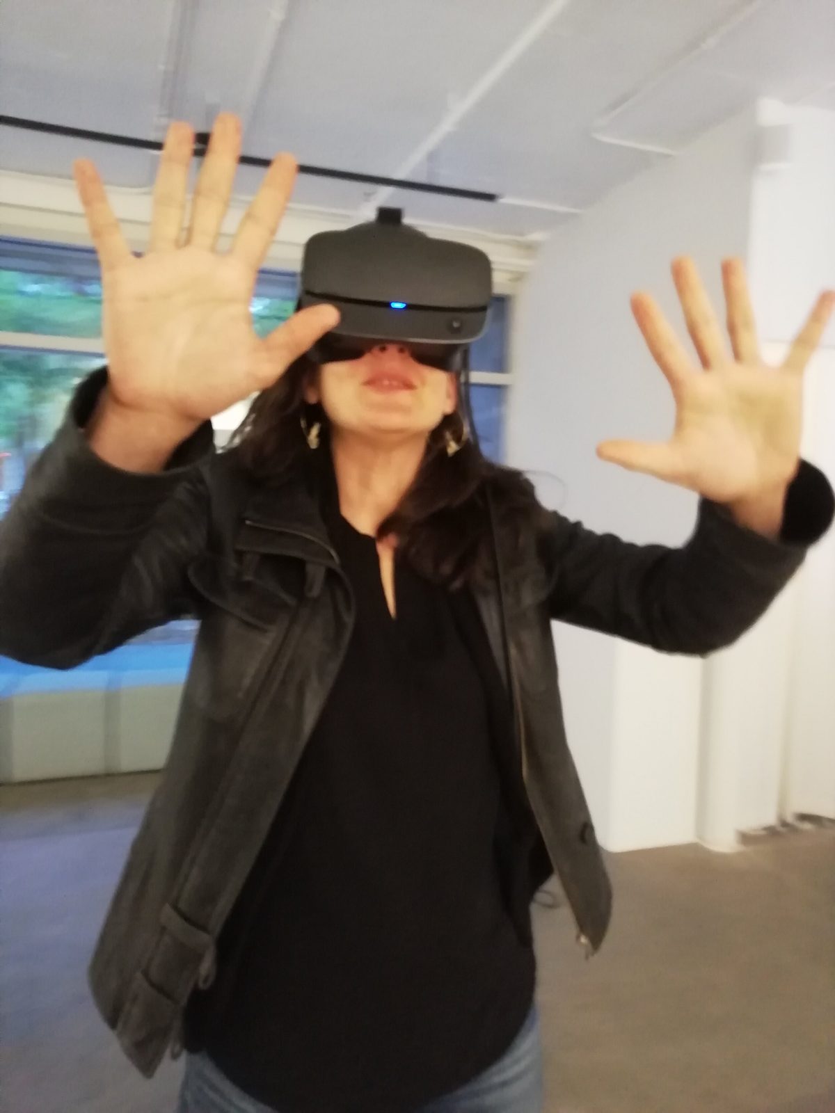 Salvo exhibition — close-up of visitor with VR headset, hands spread wide in wonder